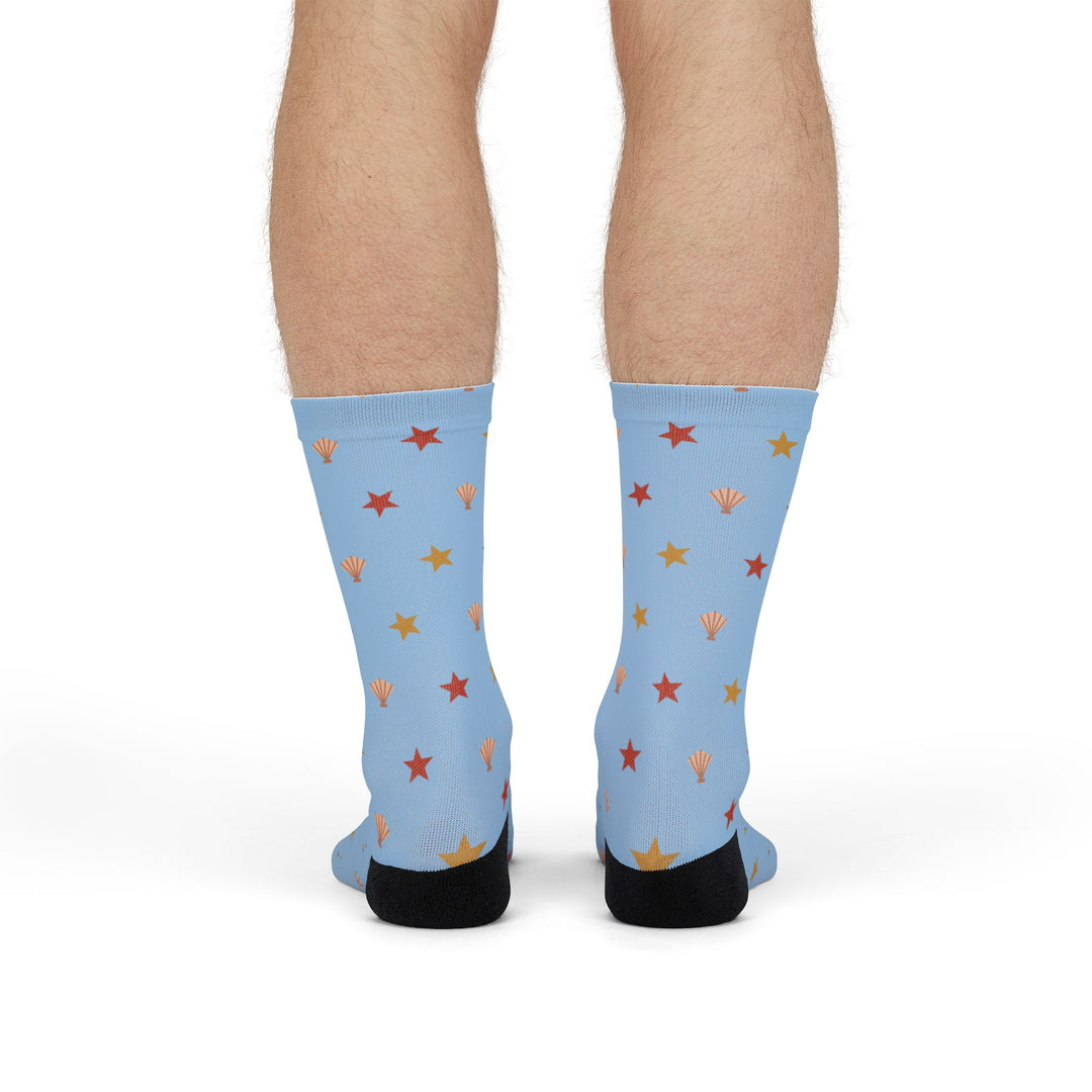 Front view of a model standing in light blue Beachcomber starfish and shell Rhode Island socks