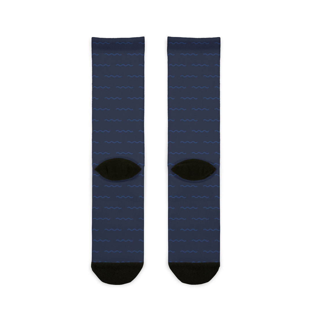 Back flat lay of plain navy compass rose sailing socks with black heels and black toes