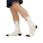 Model mid-stride in denim shorts wearing One More Crossing Block Island socks with wave print