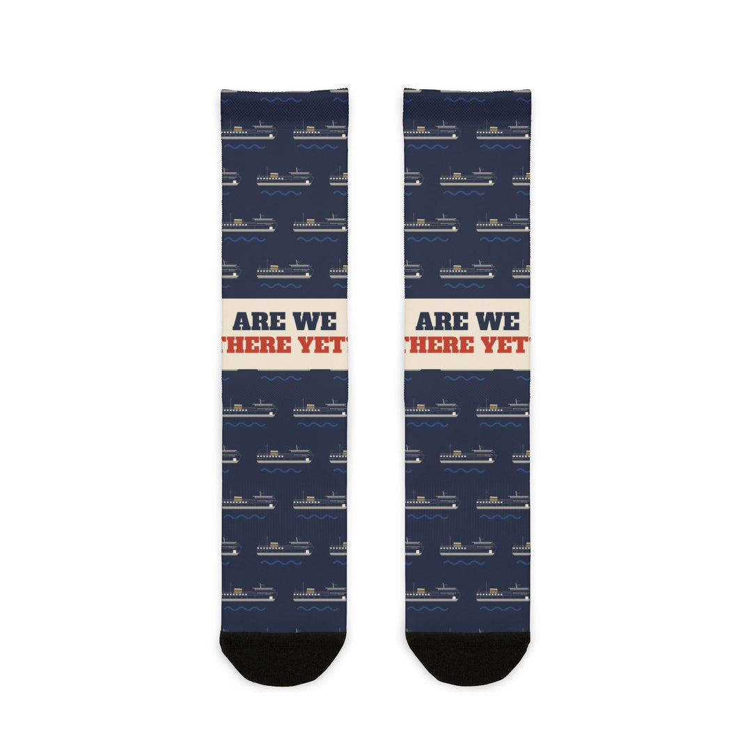 Are We There Yet? Block Island socks laid flat: navy crew socks with ferry print, cream slogan band, black toes
