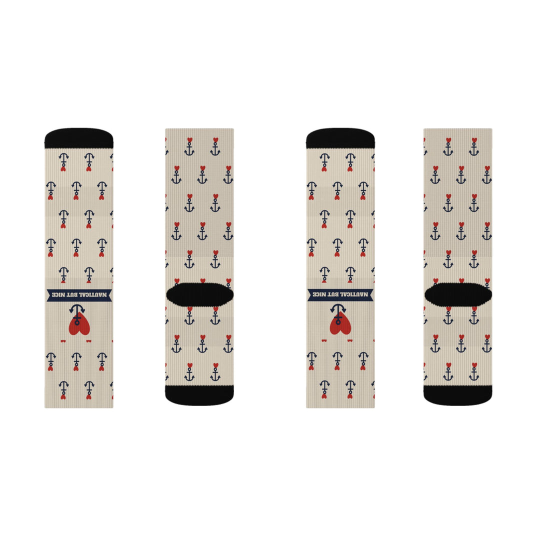 Two tan pairs of Nautical But Nice nautical crew socks laid flat, front banner and heart, back black heels