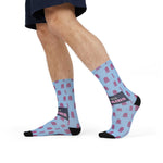 Mid-stride side view of I'd Need 4 Pairs funny ocean socks showing the navy slogan band