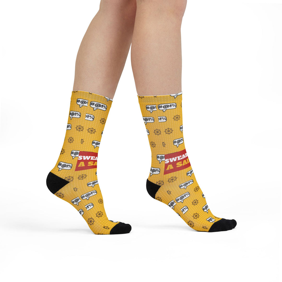 Model walking in yellow Swear Like a Sailor crew socks with #@!% bubbles, ship wheels and black toes, side view