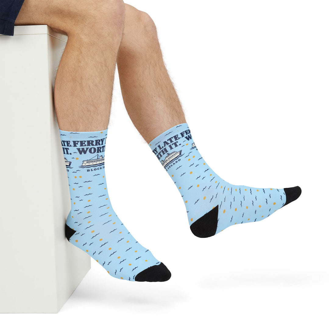 Seated model with crossed legs wearing light blue Ferry Late. Worth It. funny Block Island ferry socks