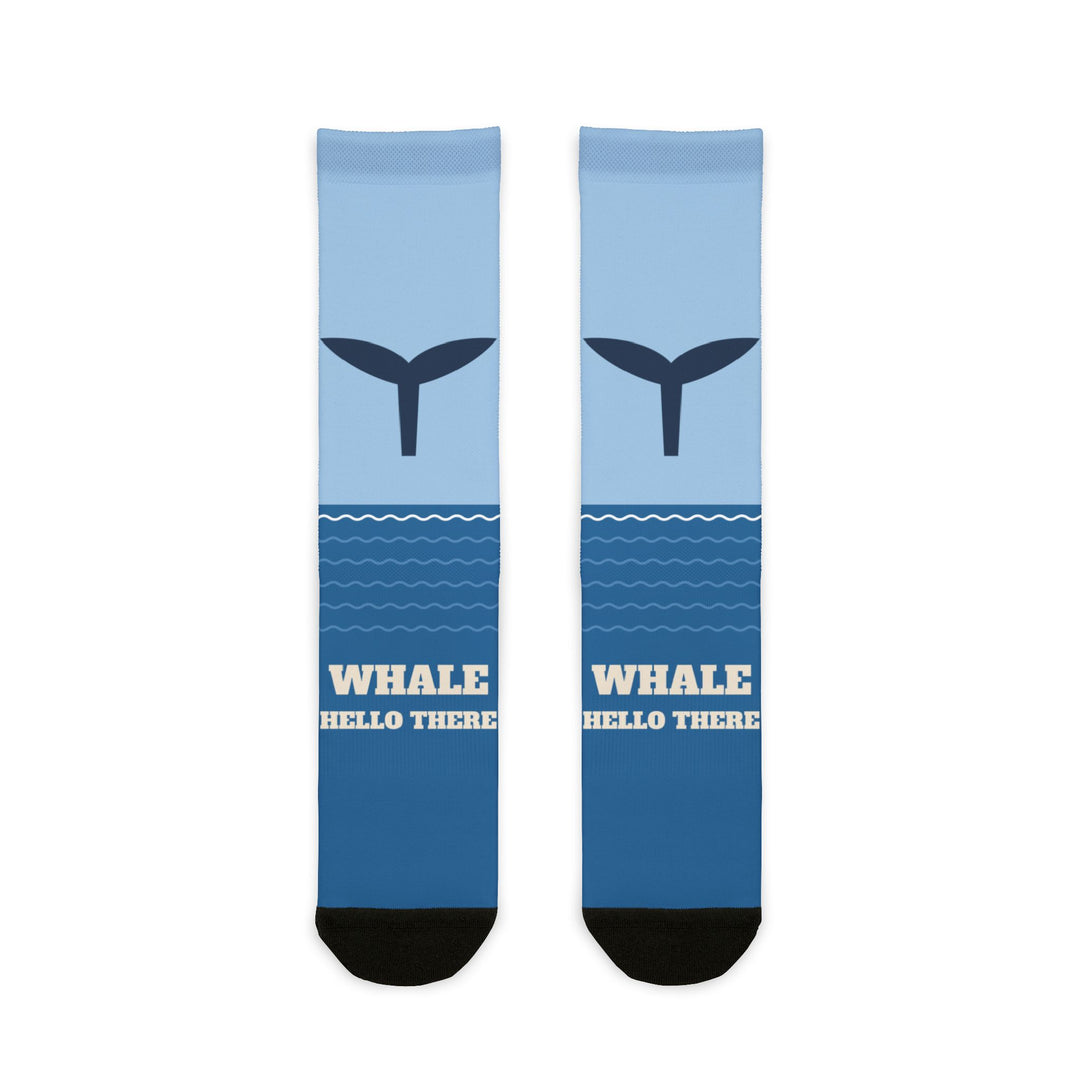 Whale Hello There socks laid flat: light-to-deep blue ocean socks with a navy whale tail and black heel and toe