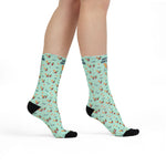 Model standing in mint green Off Duty. On Island. funny beach socks with cocktail print, side view