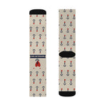 Flat lay of tan nautical crew socks, front with navy Nautical But Nice banner and heart, back with black heel