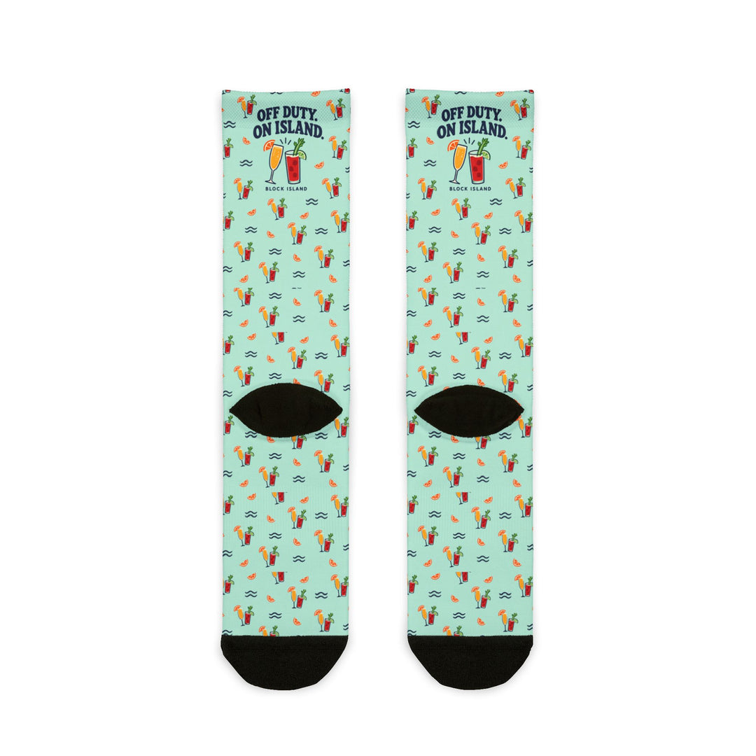 Back of mint green Block Island cocktail socks flat lay with drinks, orange slices and waves, black heels