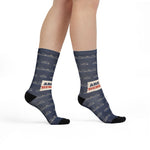 Model walking in Are We There Yet? Block Island socks, front view of the cream slogan band on navy socks
