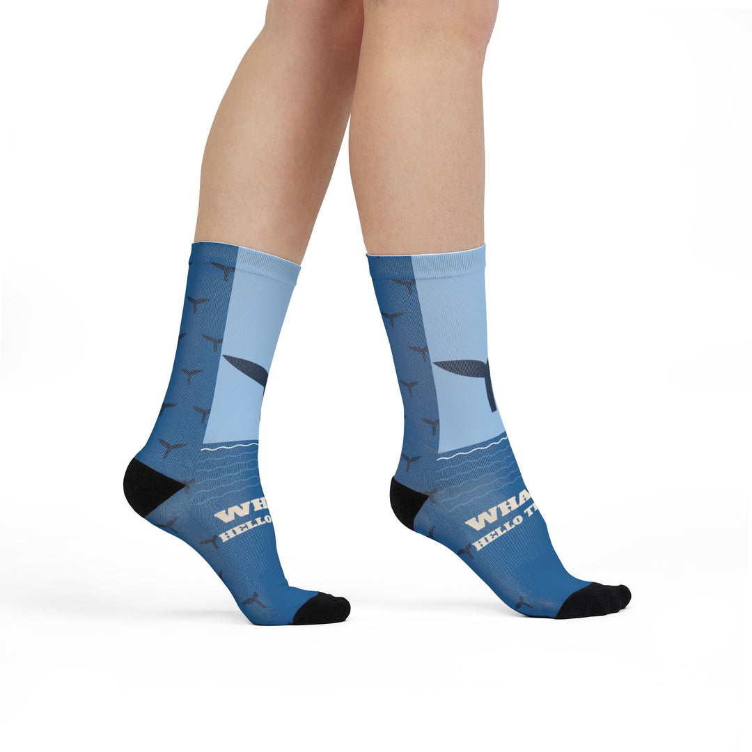 Model walking in Whale Hello There crew socks, front view of the whale tail and slogan on blue gradient socks