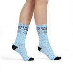 Model walking in Ferry Late. Worth It. Block Island socks, front view of the ferry graphic on light blue crew socks