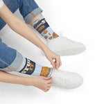 Seated model in rolled jeans tying a white sneaker in Stuff It. Rhode Island stuffie crew socks