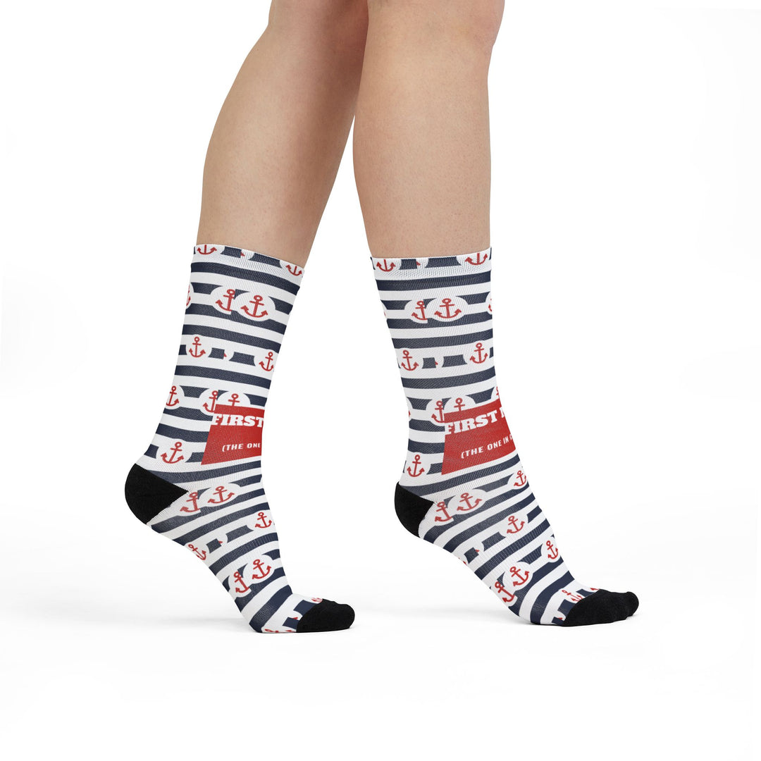Model walking in striped First Mate anchor socks, side view of the red slogan band on funny beach socks