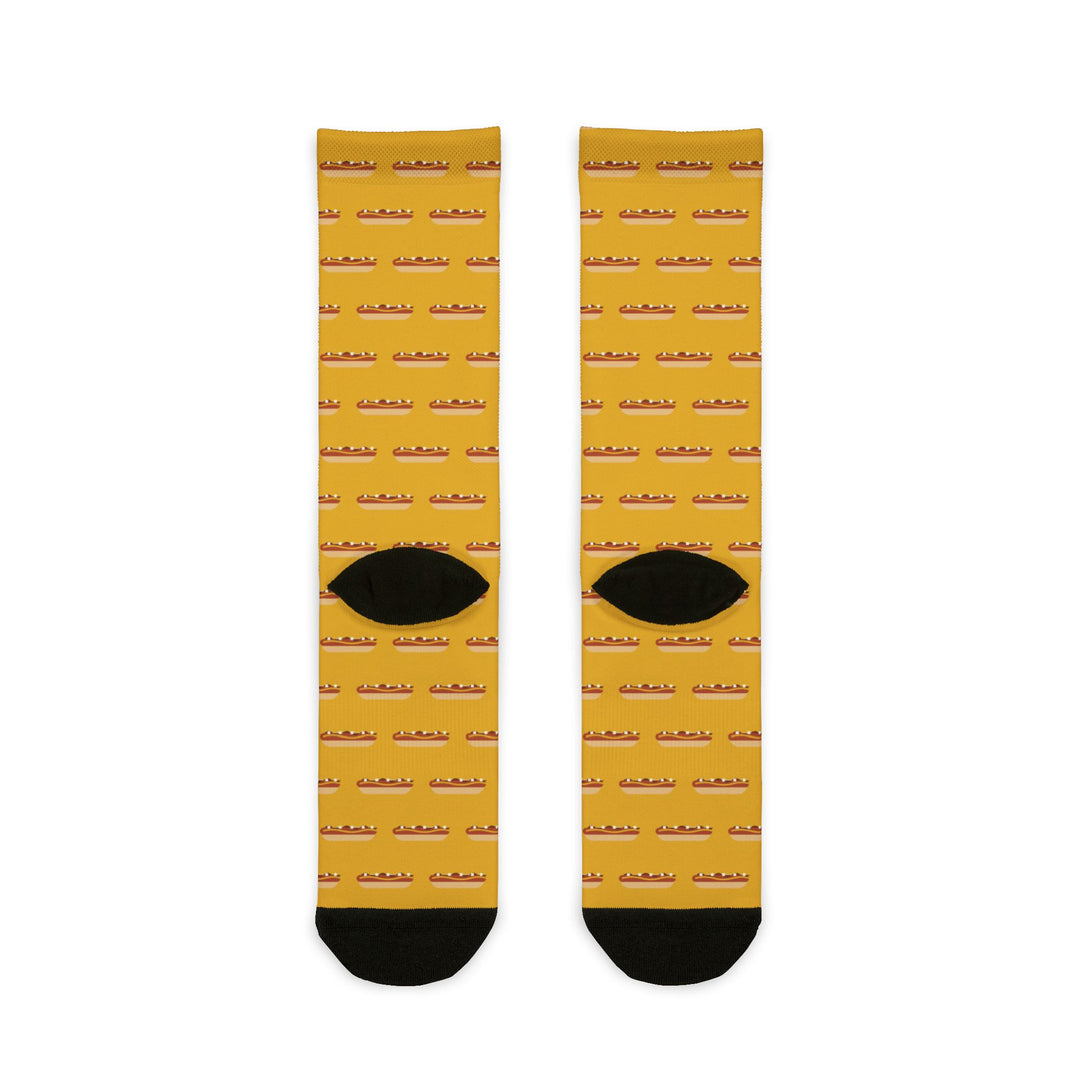 Back of mustard yellow Rhode Island hot wiener socks flat lay with rows of wieners and black heels