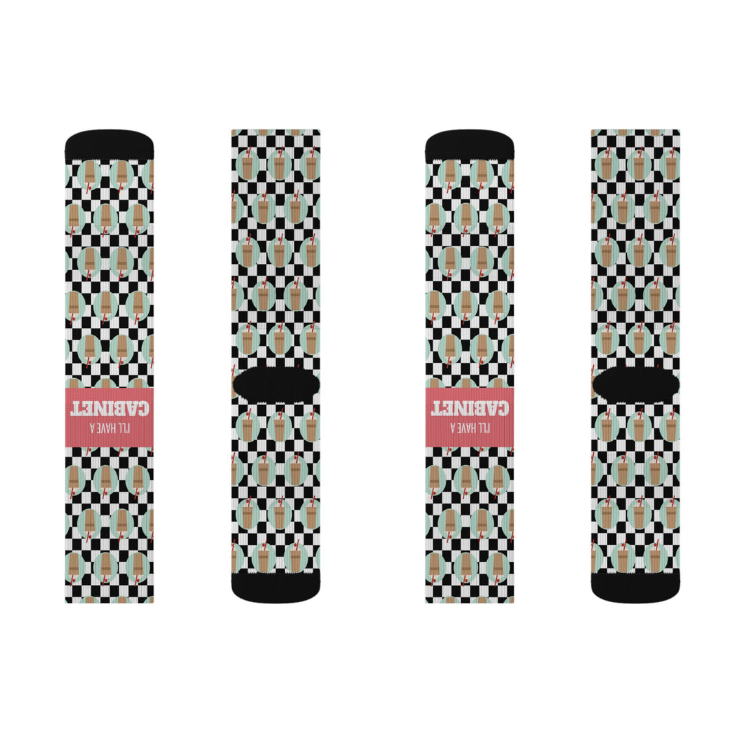 Second flat lay of four checkered I'll Have a Cabinet Rhode Island socks in a row, two showing the coral slogan band