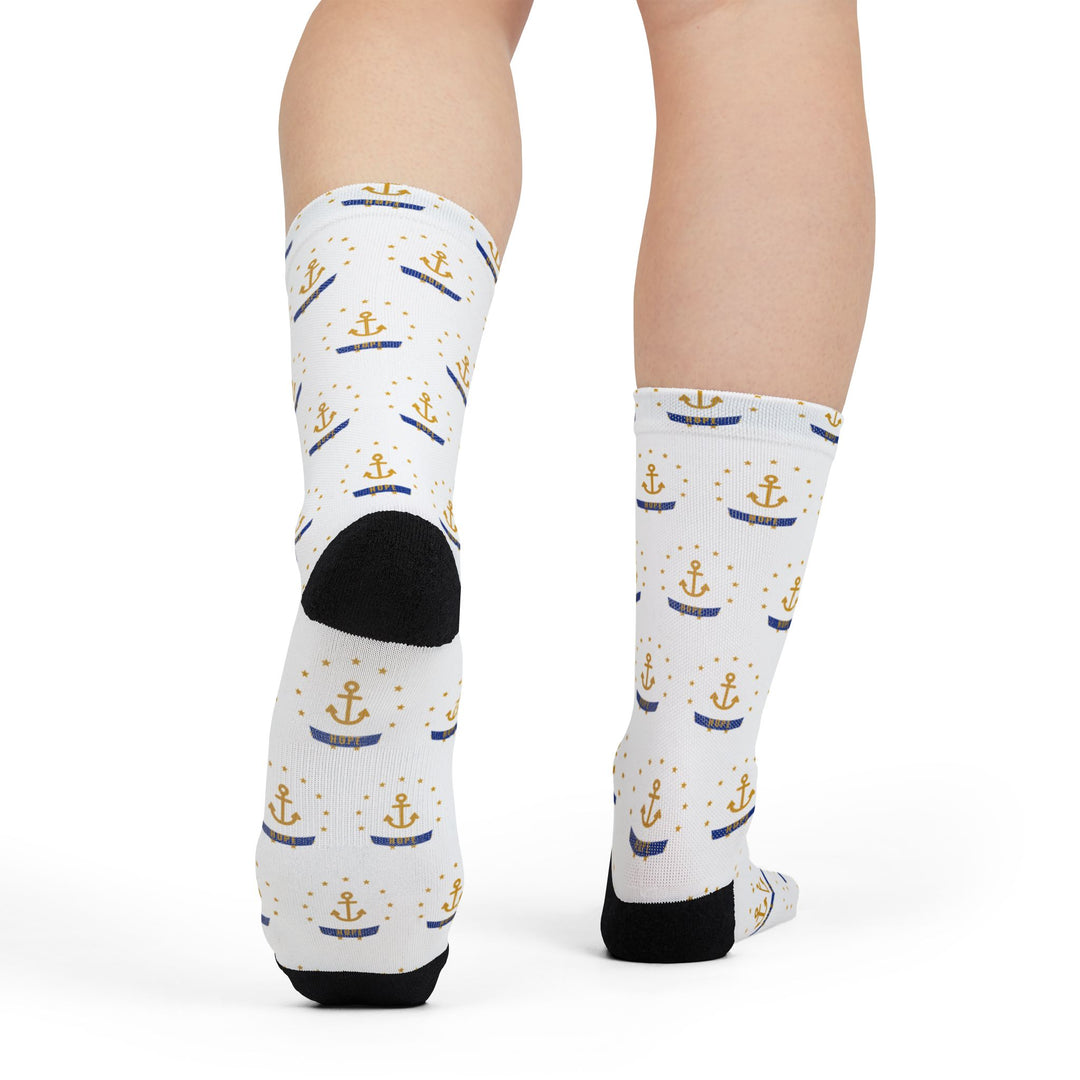 Rear view of legs in white Smallest State Biggest Mouth funny beach socks showing black heels and anchor print