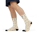 Side view of a walking model in cream Rhode Island crew socks with the Powered by Coffee Milk pattern