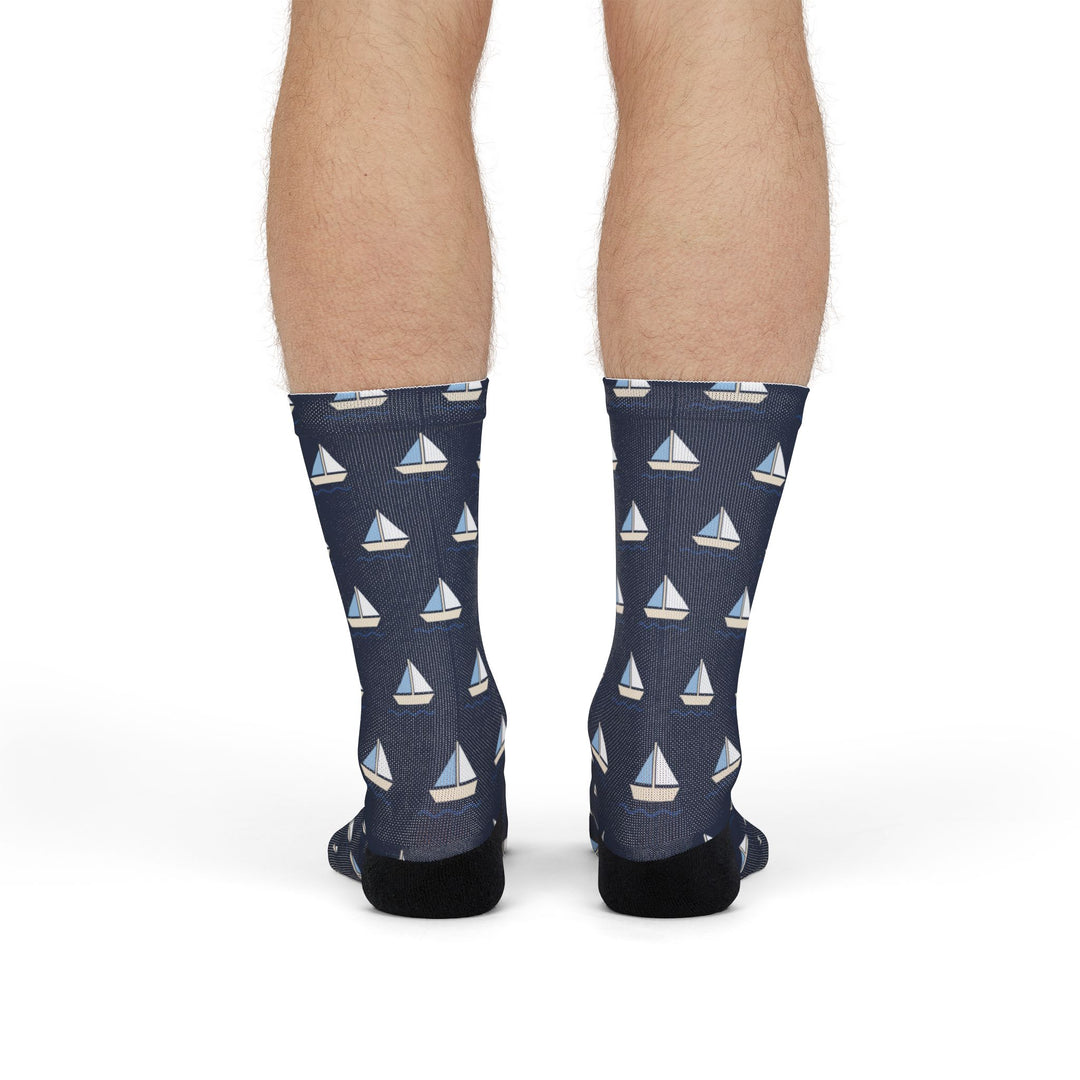 Front view of legs standing in navy Captain of the Couch nautical crew socks with white sailboat print