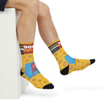 Crossed legs in yellow Squid Pro Quo socks with pink squid graphic, a funny Rhode Island calamari gift