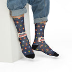 Model in rolled jeans sitting on a white block showing the Nice Buoys slogan on navy funny beach socks