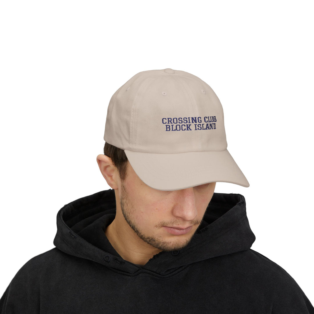 Man in a black hoodie wearing the Stone Crossing Club Block Island hat, front view with head tilted down