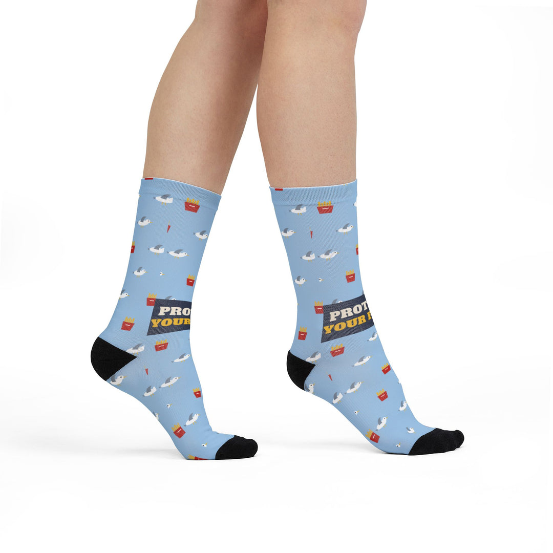 Model walking in light blue funny beach socks with seagulls and fries, side view with black heel and toe