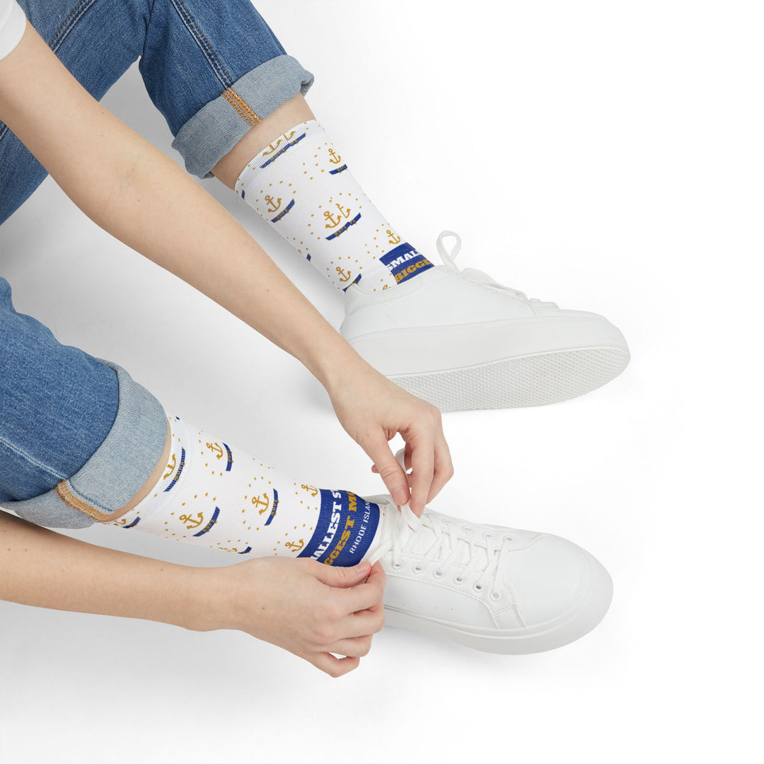 Seated model tying a white sneaker in Smallest State Biggest Mouth funny beach socks with blue slogan band