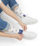 Seated model tying a white sneaker in Smallest State Biggest Mouth funny beach socks with blue slogan band