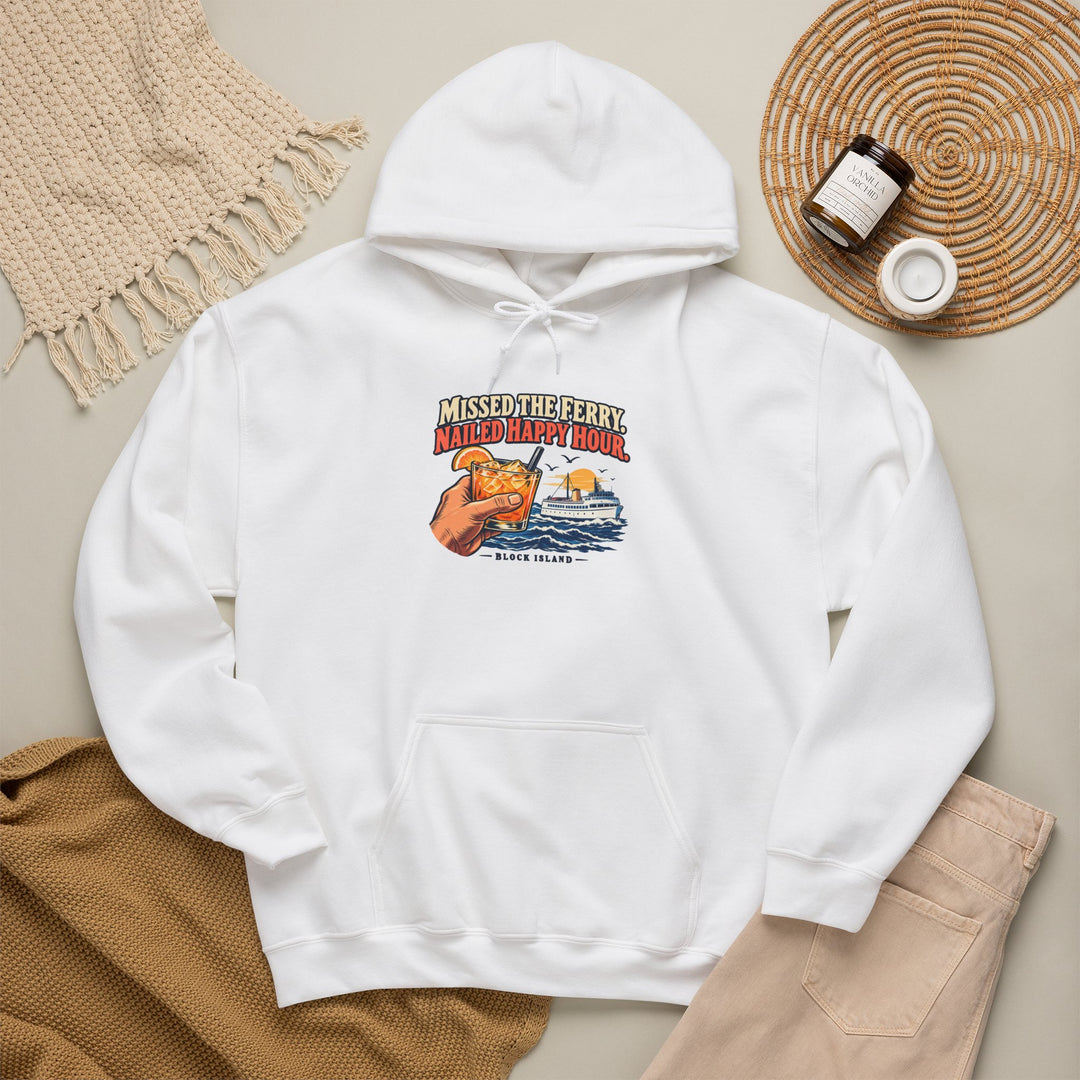 White Block Island gift hoodie laid on a wooden floor beside a woven basket, candle and dried grass