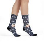 Model mid-step in navy Captain of the Couch nautical crew socks with white sailboats and black toes