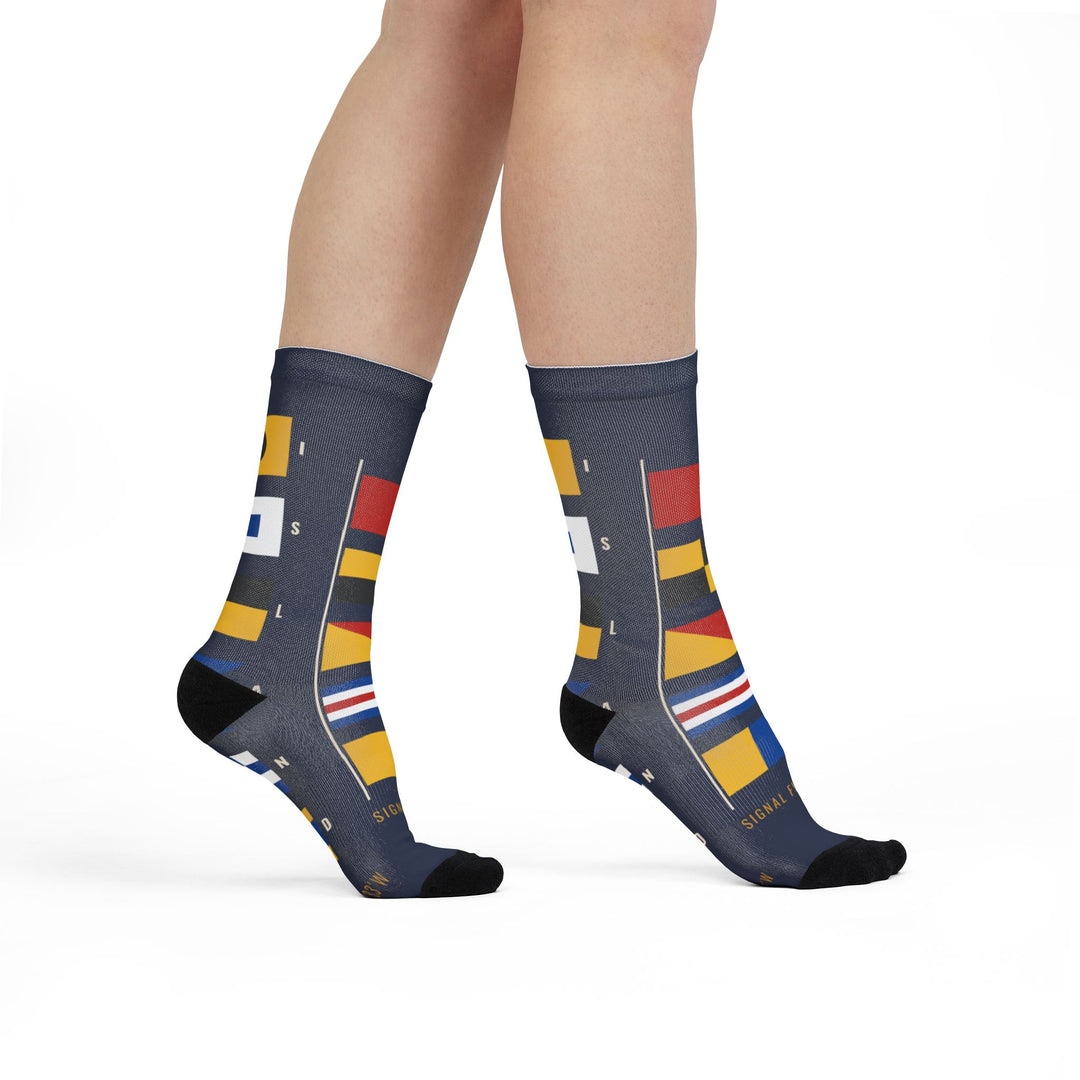 Model walking in navy Block Island socks, front view of the stacked signal flags spelling out the island name