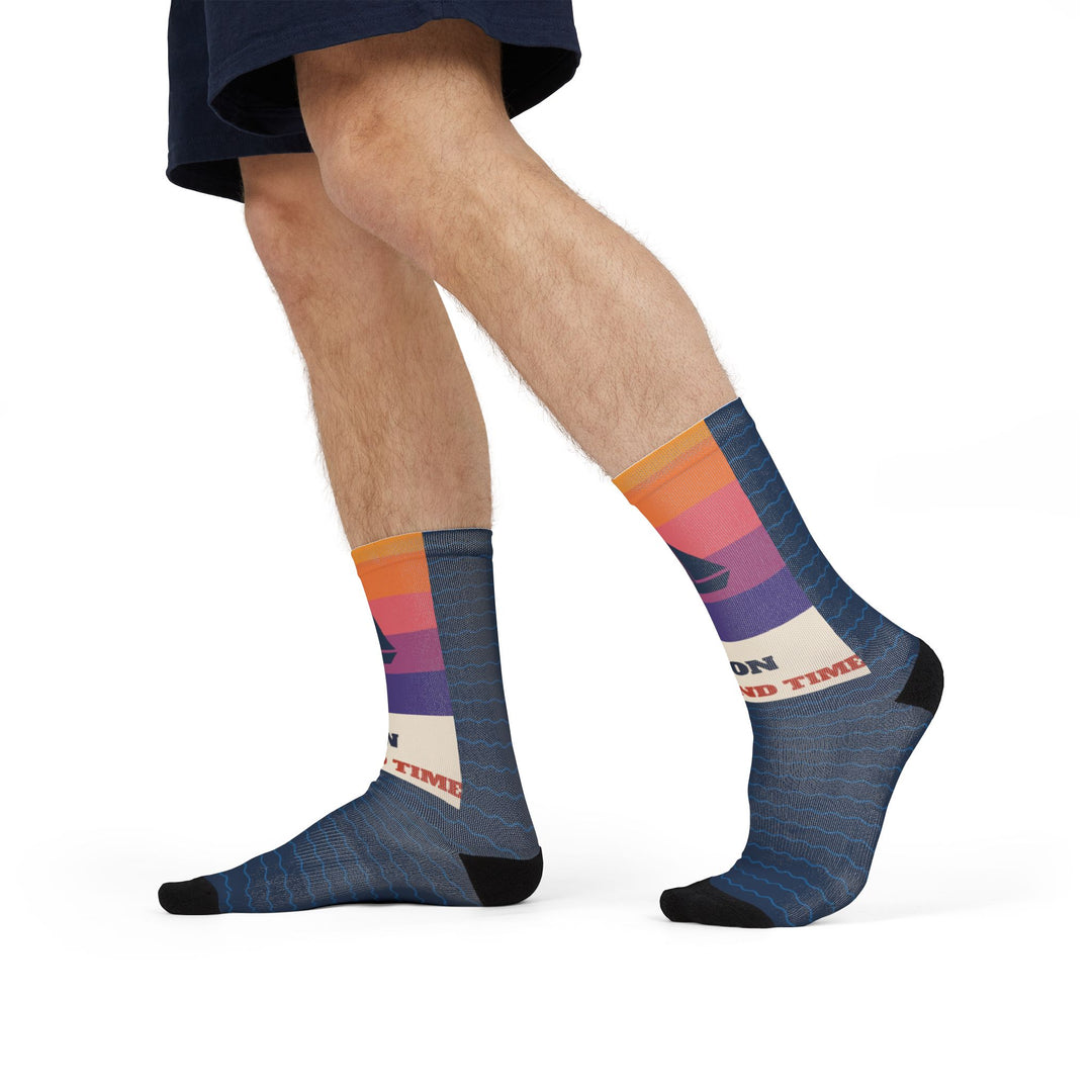 Side stride view of On Island Time sunset sail socks on a model, sailboat cuff and navy wave foot