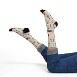 Model in jeans leaning back with feet up in tan Nautical But Nice sailor socks, a nautical gift for boaters