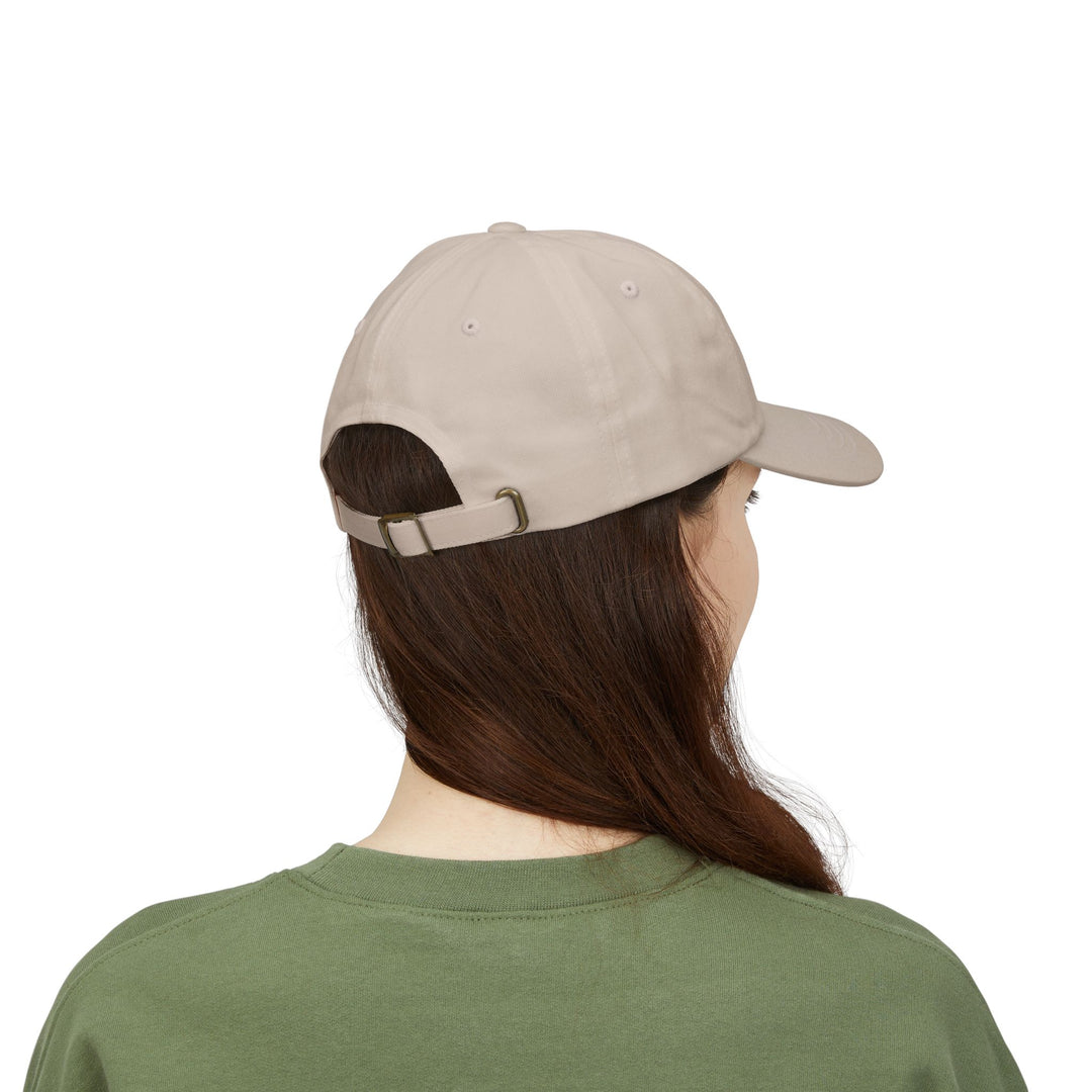 Woman in a green tee shown from behind wearing the Stone Block Island baseball cap with metal buckle