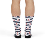 Front of the legs of a standing model in navy-striped Hold Fast anchor socks with red anchors, nautical crew socks