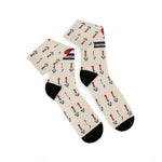 Folded pair of tan nautical crew socks showing black heels and the red heart and anchor tattoo print