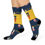 Side view of a walking model in navy Get Lit lighthouse socks with red and white lighthouses and light beams