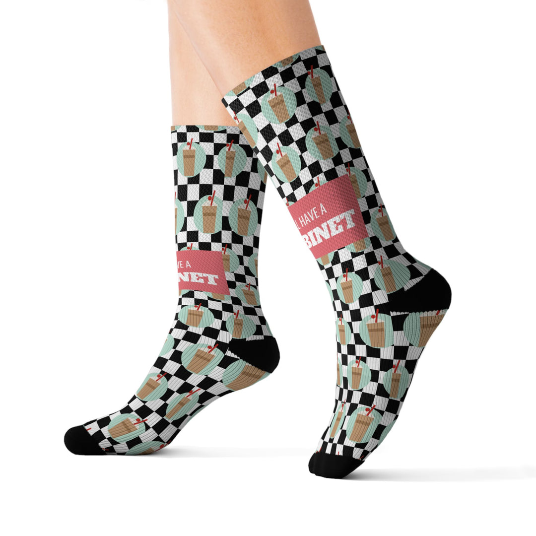 Size S coffee cabinet Rhode Island socks on leg forms mid-stride, mint and tan checkerboard with a coral slogan band