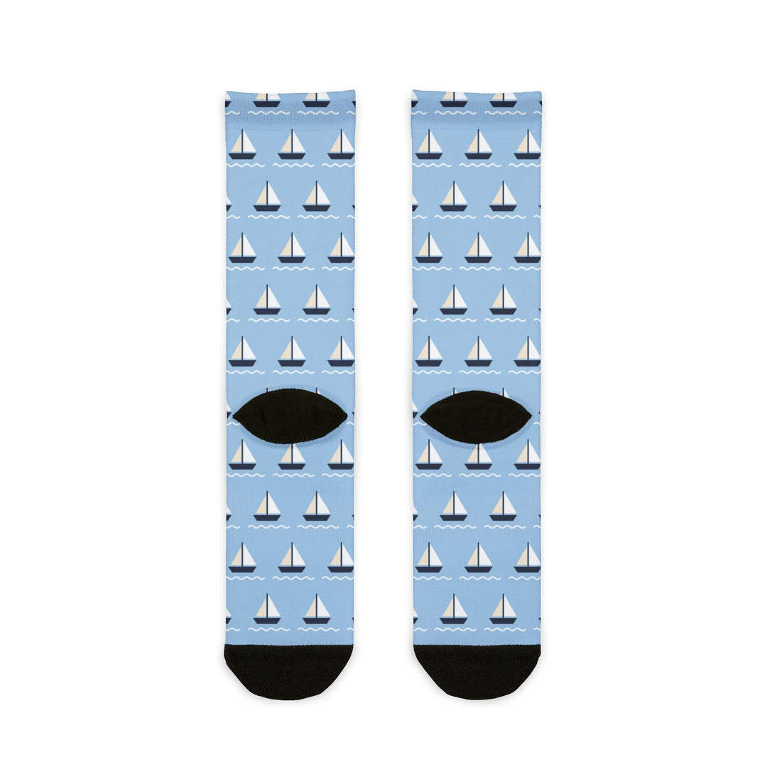 Back view of light blue sailboat socks with black heels and a repeating regatta sailboat pattern