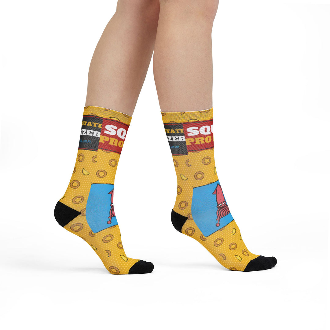 Model standing in yellow calamari crew socks with Squid Pro Quo band and pink squid on a blue panel