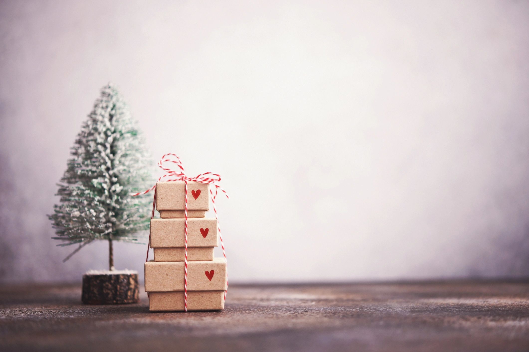 Tiny gift stack beside a seasonal tree display